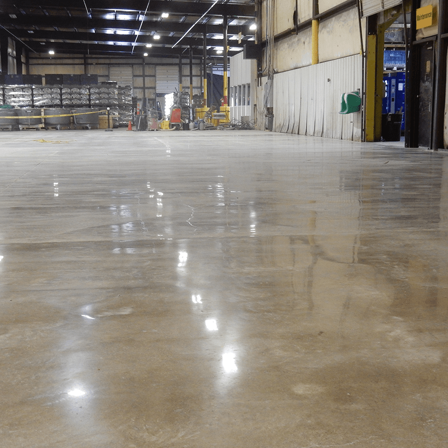 A large warehouse with a shiny concrete floor