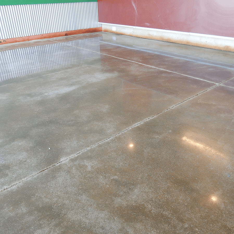 A shiny concrete floor with a red wall in the background