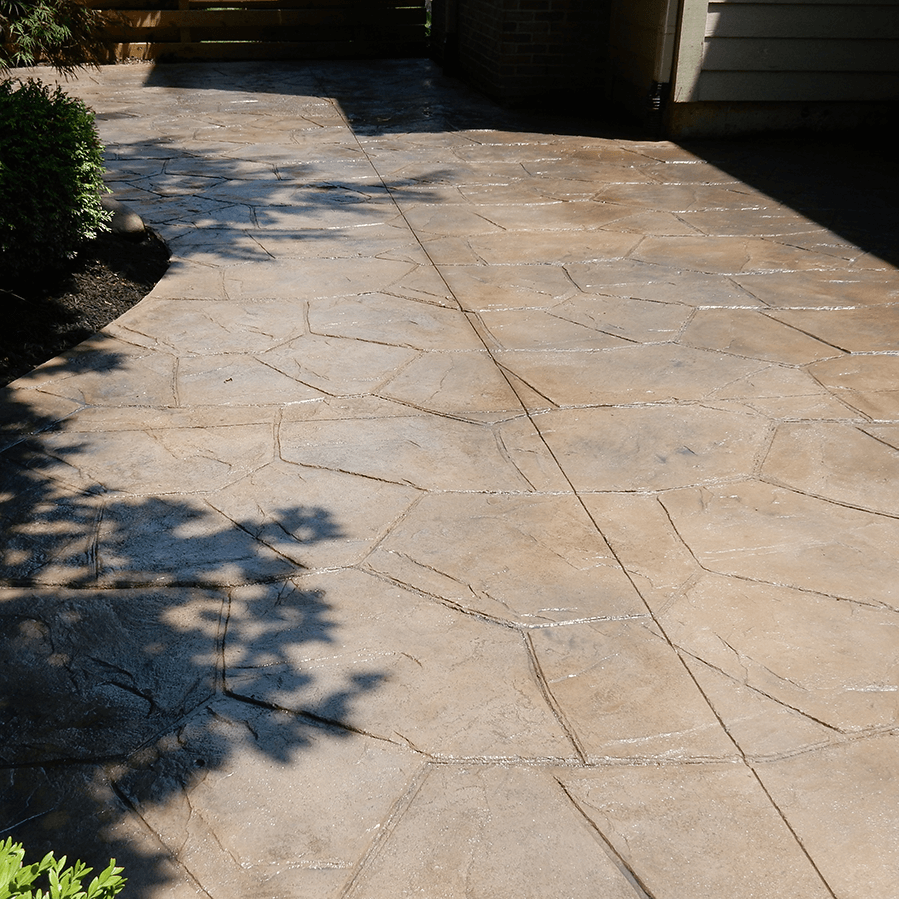 A shadow of a tree is cast on a decorative concrete walkway