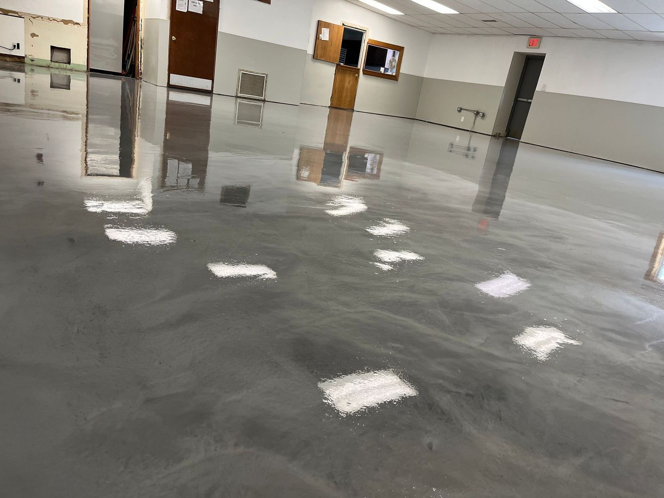 A shiny concrete floor in a room with a lot of lights on it.