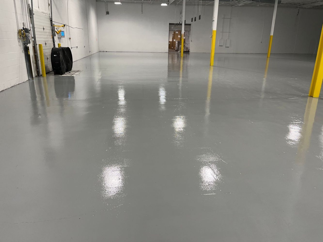 A large empty warehouse with a shiny concrete floor.