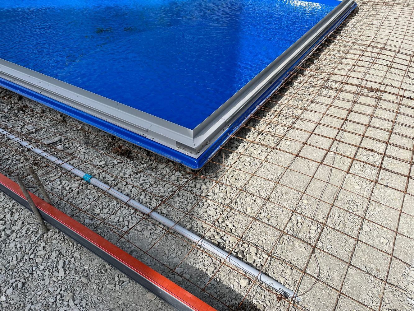 A blue swimming pool is sitting on top of a concrete surface.