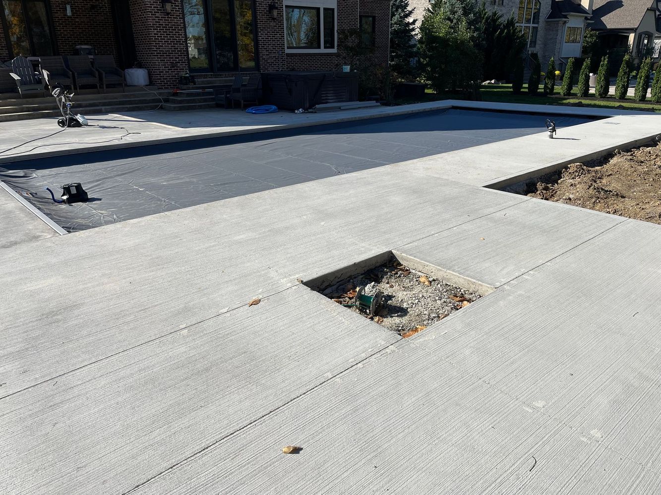 A concrete walkway is being built around a swimming pool.
