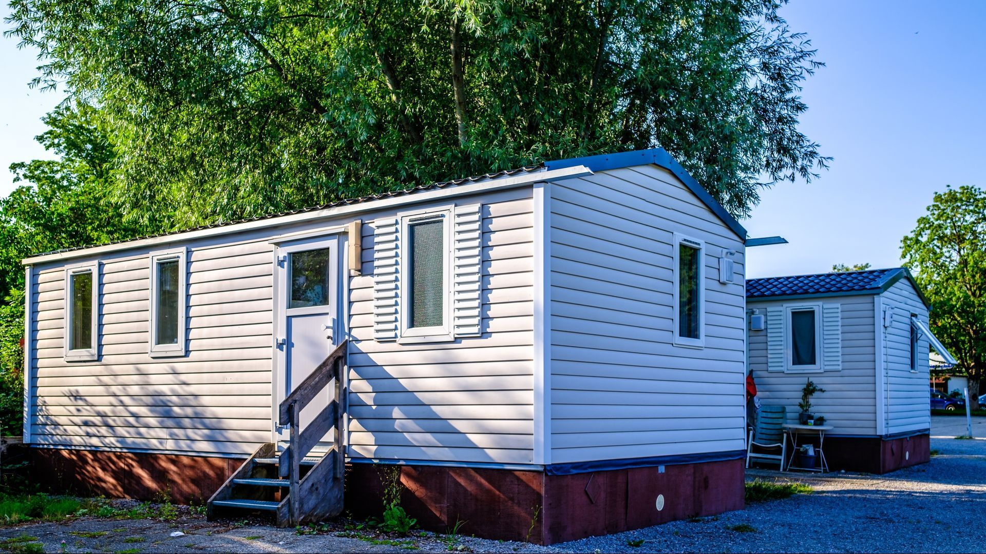 Two mobile homes are parked next to each other in a parking lot.