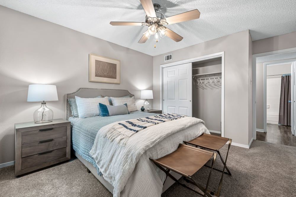 a bedroom with a bed , nightstand , dresser and ceiling fan at The Park at Flower Mound in Flower Mound, TX.
