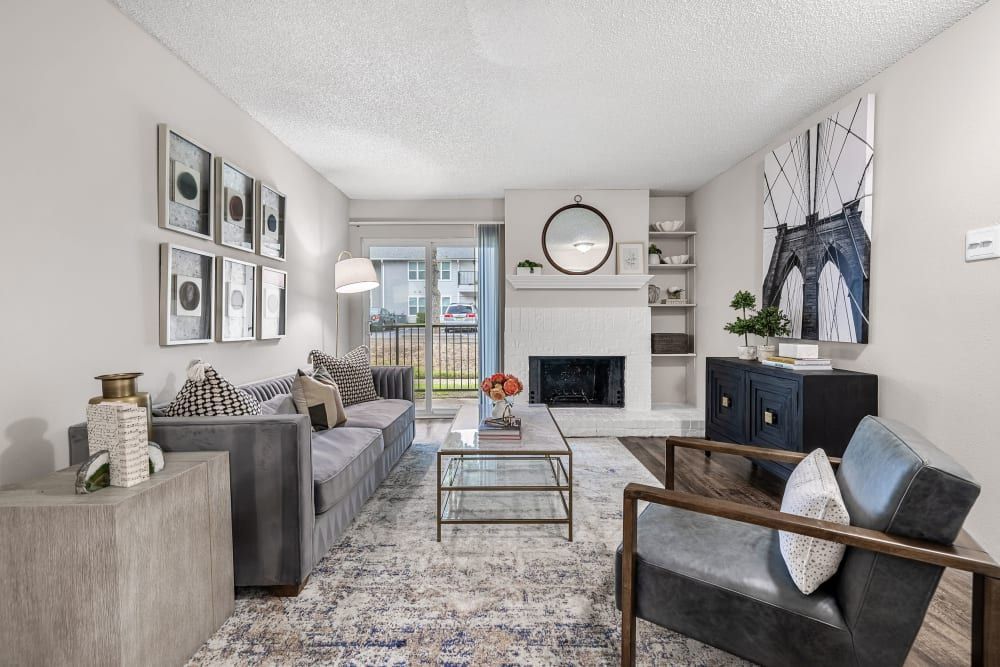 a living room with a couch , chair , coffee table and fireplace at The Park at Flower Mound in Flower Mound, TX.