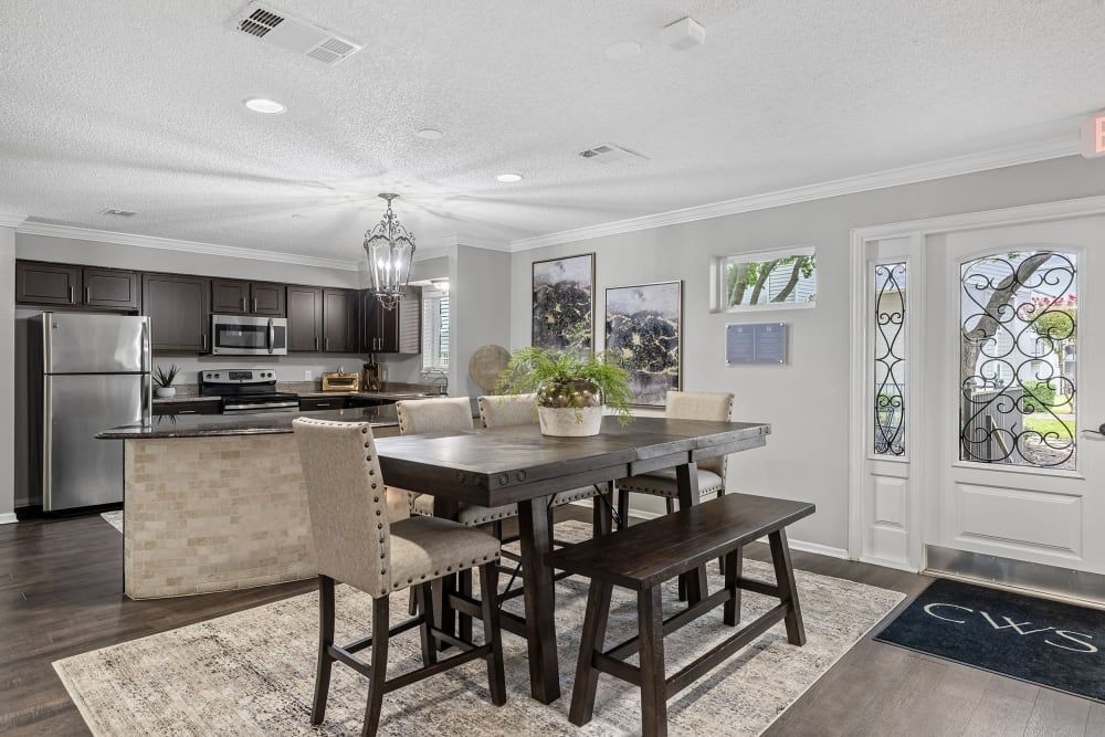 a dining room with a table and chairs and a bench at The Park at Flower Mound in Flower Mound, TX.