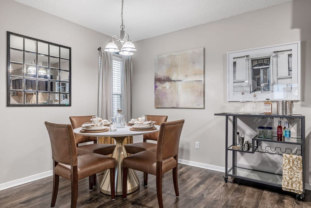 a dining room with a table and chairs and a bar cart at The Park at Flower Mound in Flower Mound, TX.