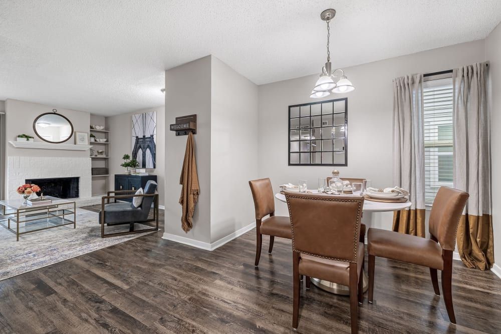a dining room with a table and chairs and a living room with a fireplace at The Park at Flower Mound in Flower Mound, TX.