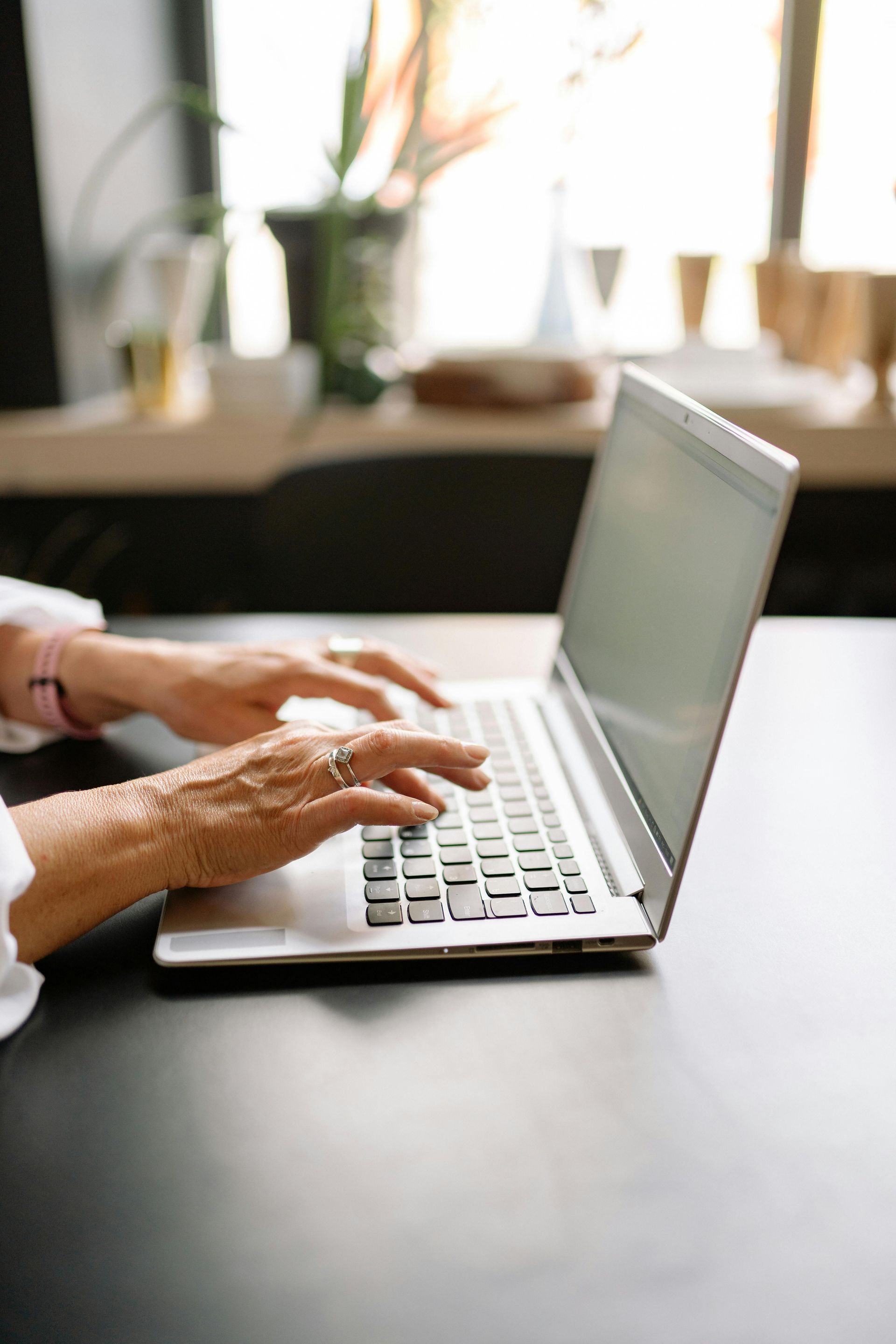 A dining room with a round table and white chairs in a house.