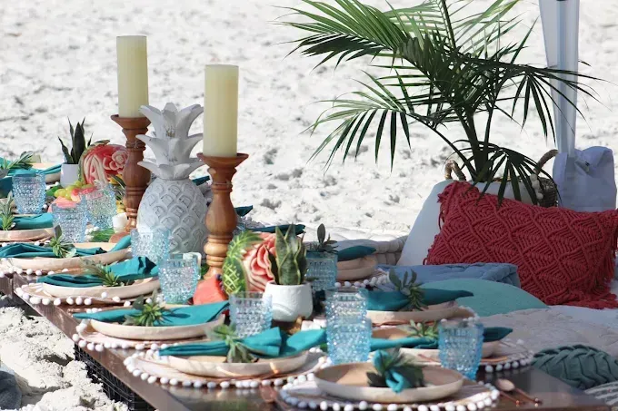 Table setting with fruit bowl, blue flowers, and place settings.