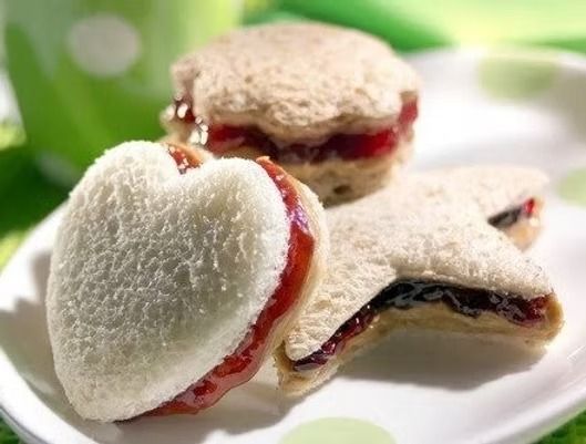 Heart-shaped and star-shaped jam sandwiches on a white plate.