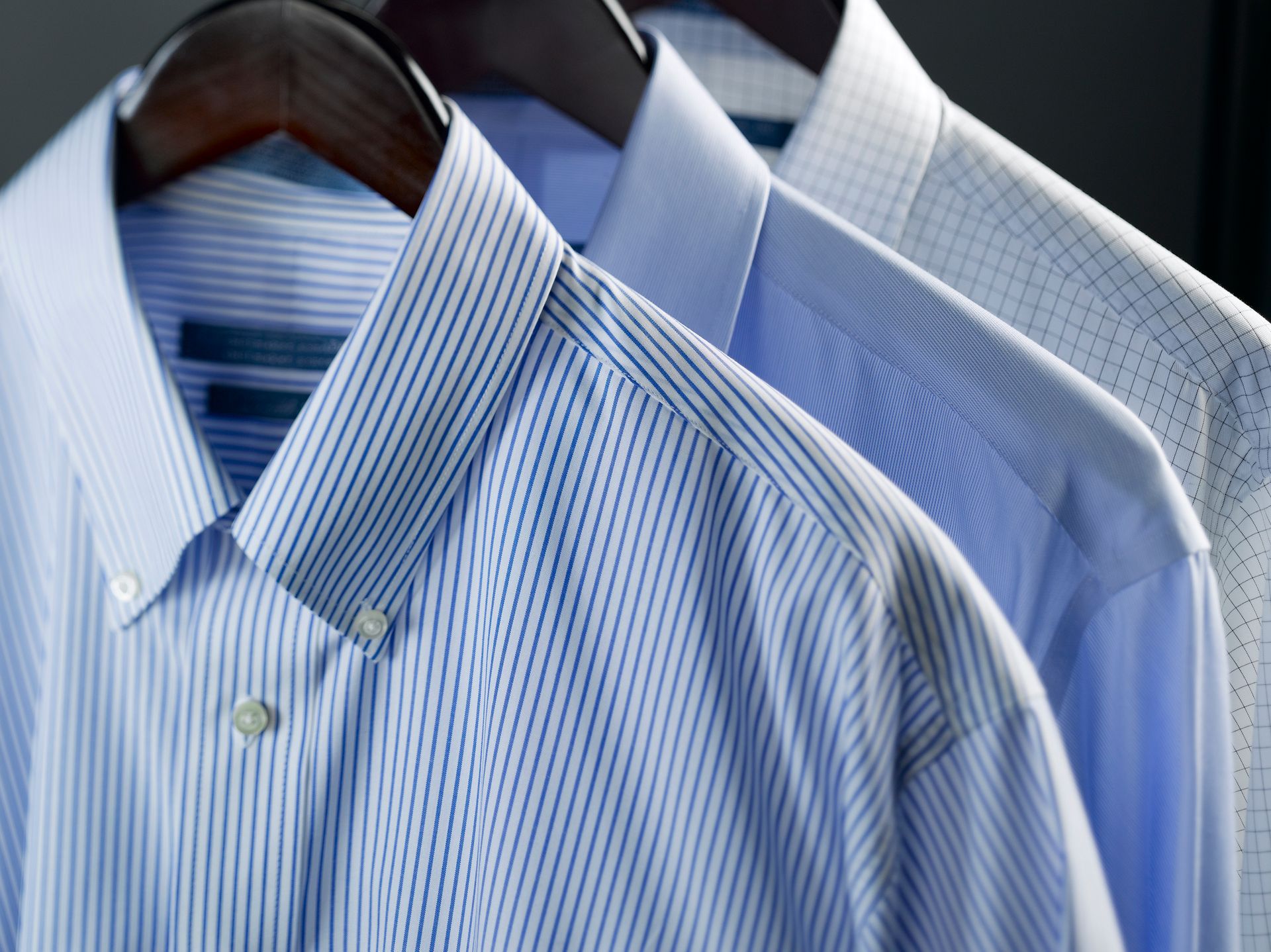 Rack of mens dress shirts, highlighting expert dry cleaning services for fresh garments.