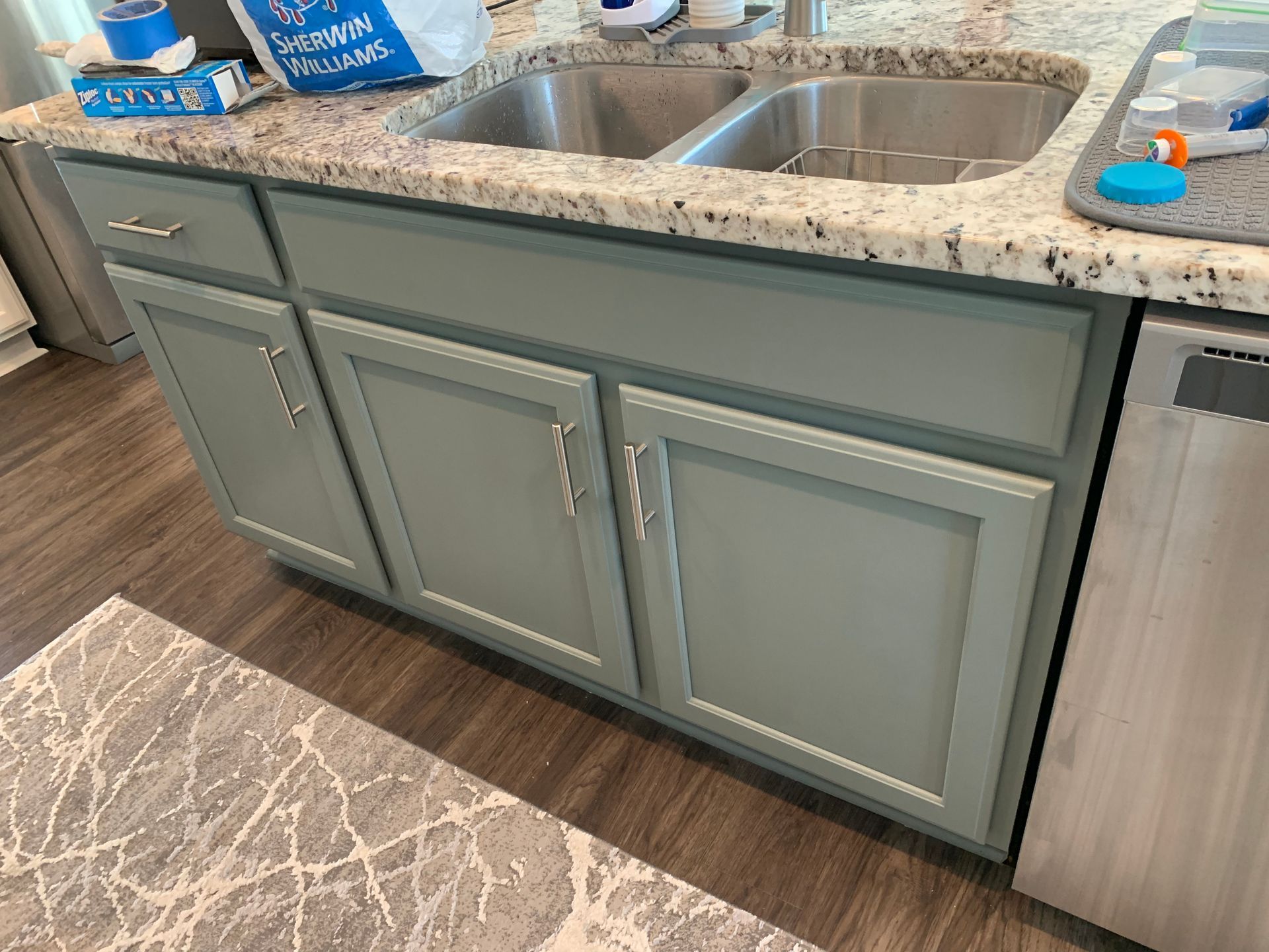 A kitchen with a sink , cabinets , and a dishwasher.