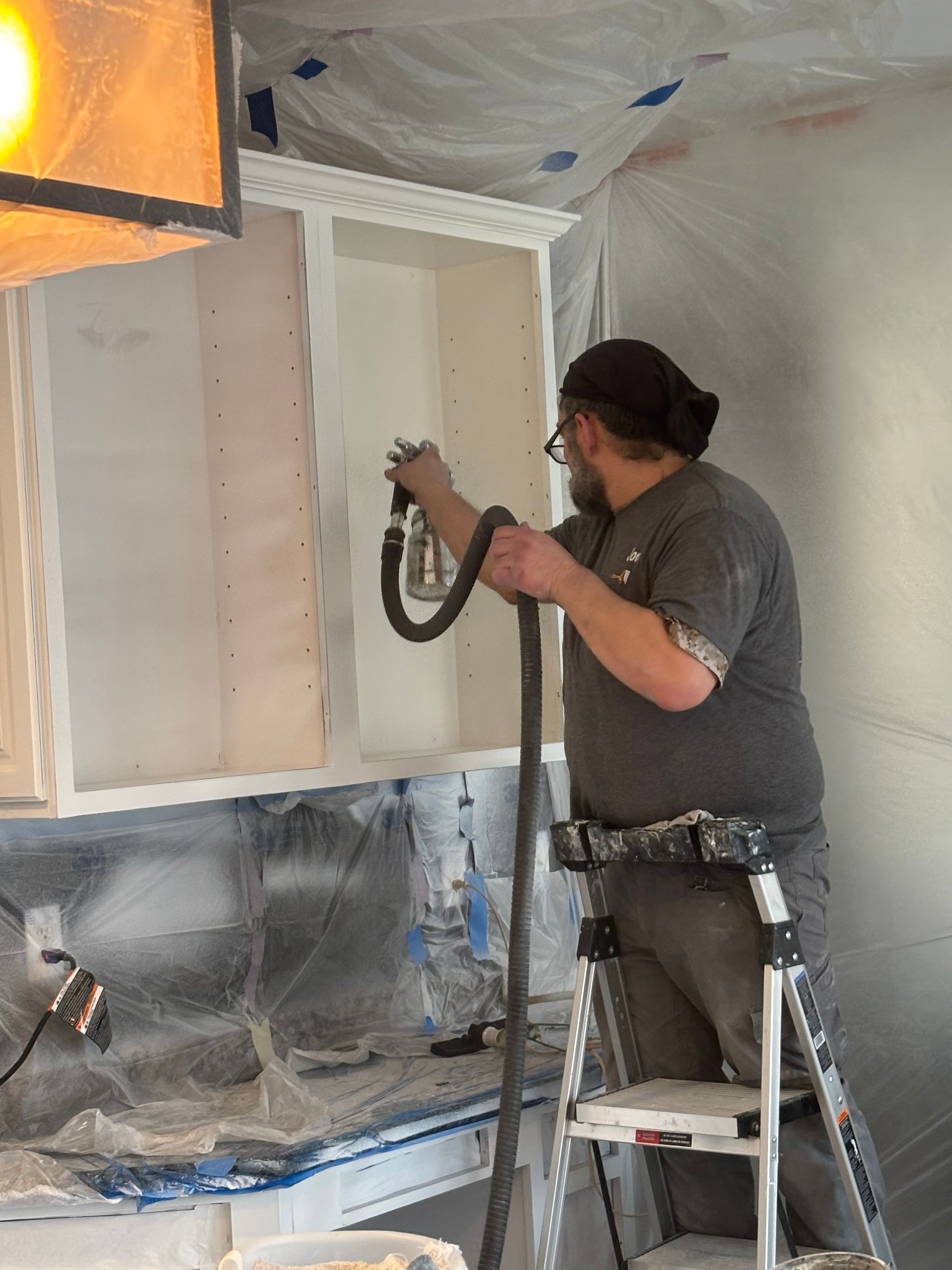 A kitchen with white cabinets and granite counter tops.