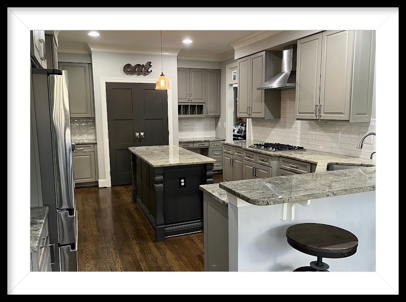 A kitchen with gray cabinets , granite counter tops , stainless steel appliances and a large island.
