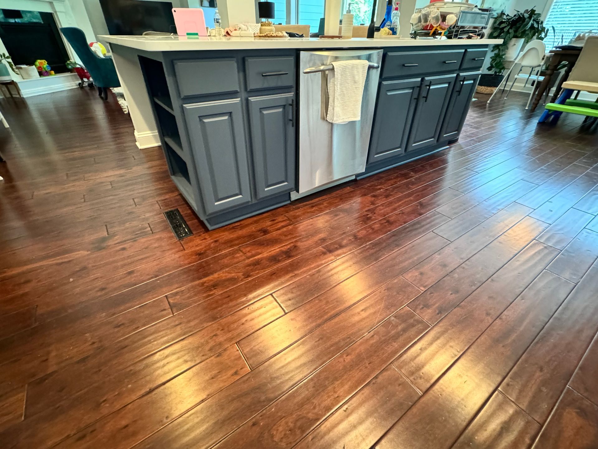 A kitchen with a large island in the middle of it and hardwood floors.
