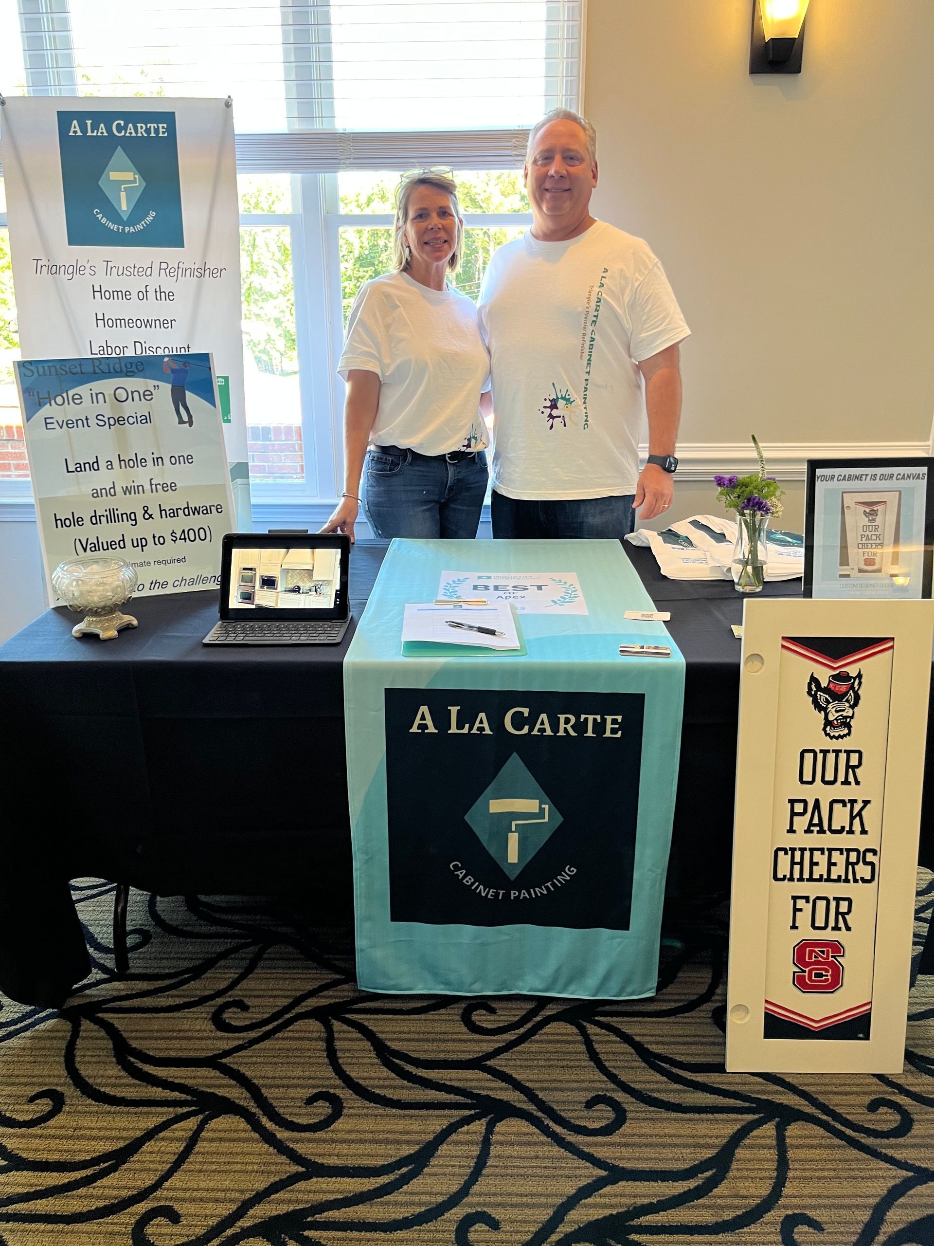 A man and a woman standing in front of a table that says a la carte