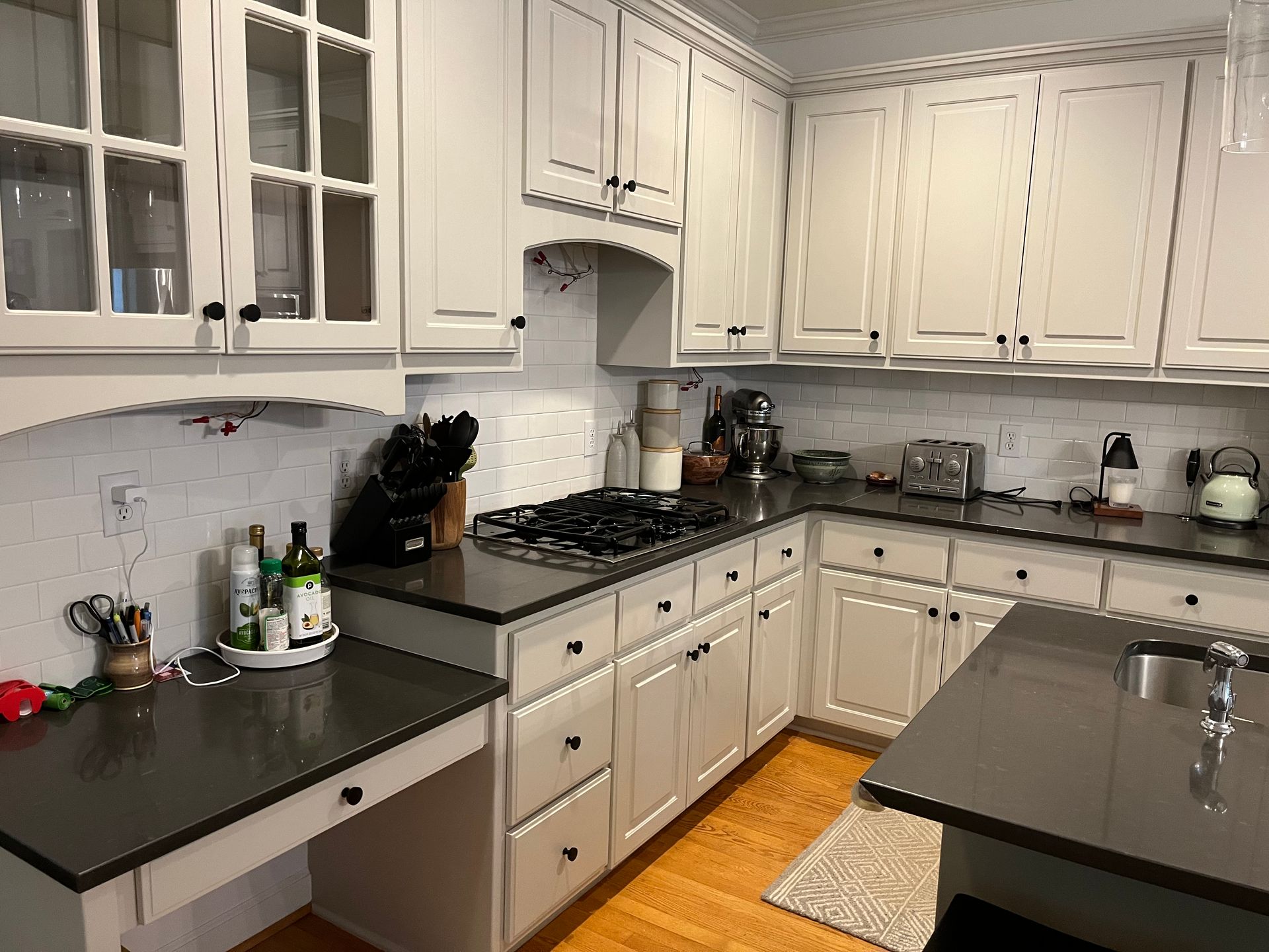 A kitchen with white cabinets and black counter tops