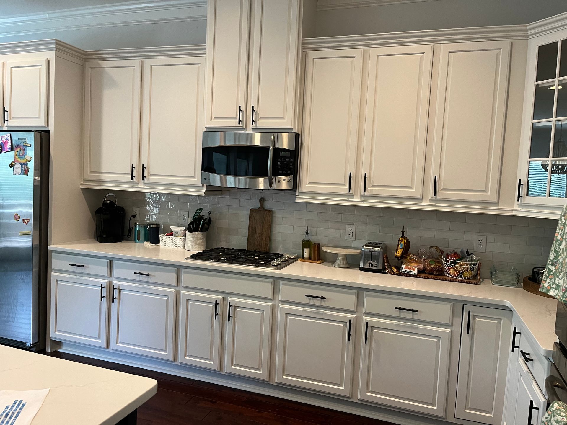 A kitchen with white cabinets and stainless steel appliances.