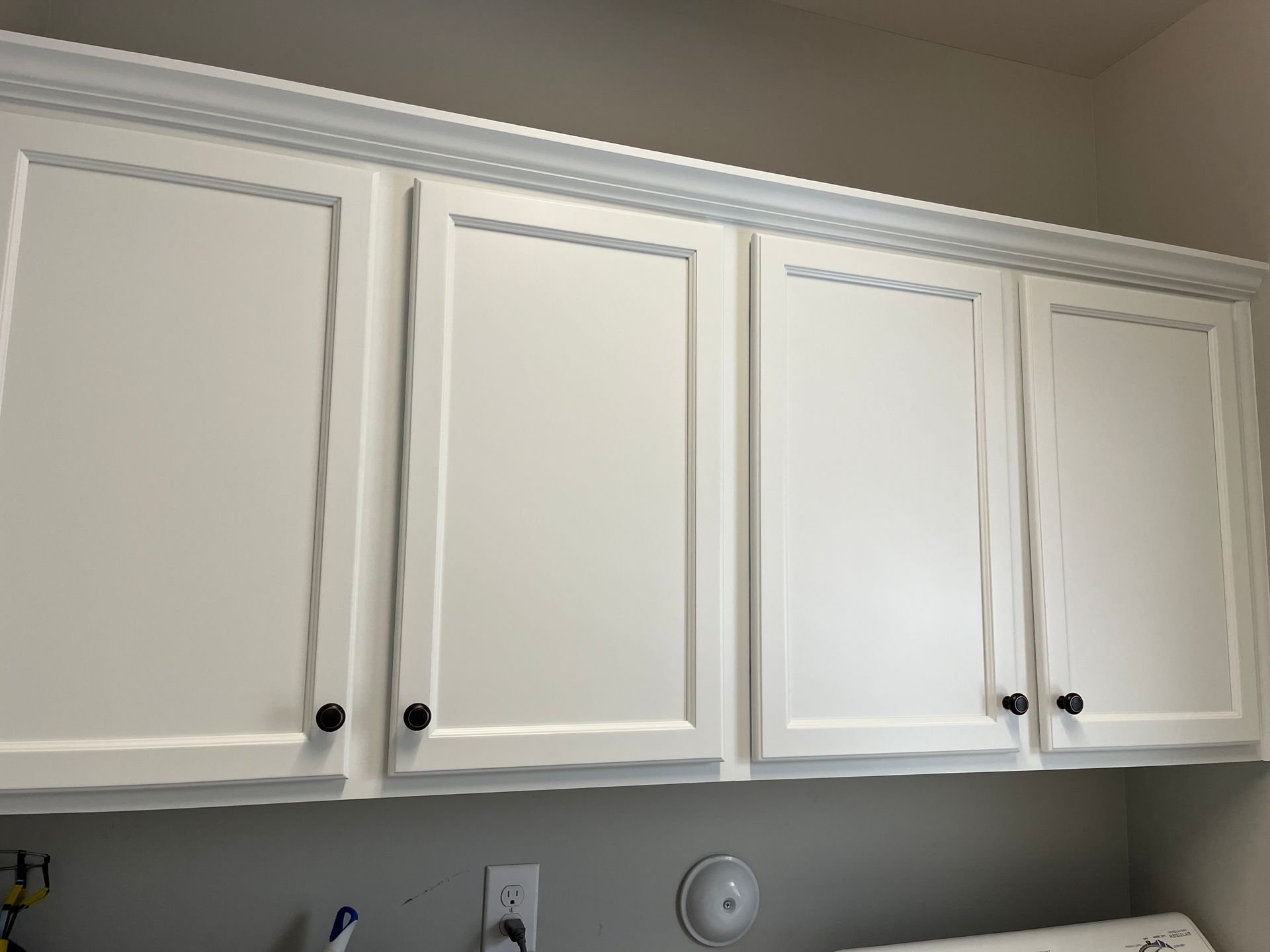 A laundry room with white cabinets and a washer and dryer.