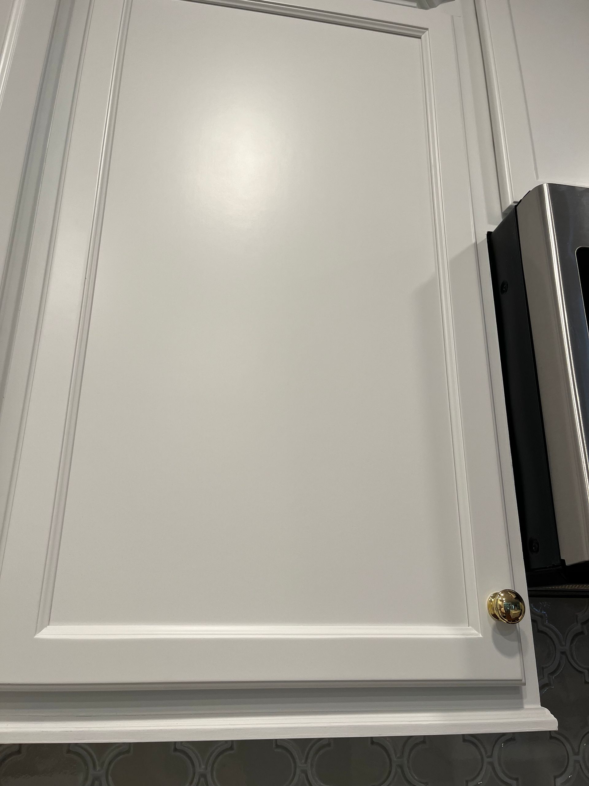 A close up of a white cabinet door in a kitchen.
