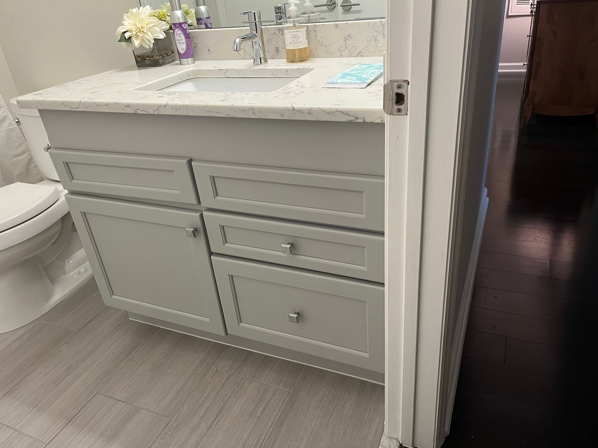 A bathroom with a sink , toilet , and cabinets.