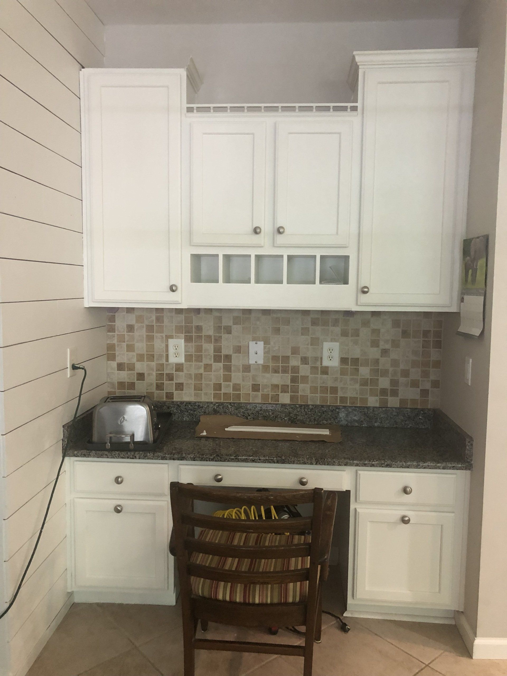 A kitchen with white cabinets and granite counter tops