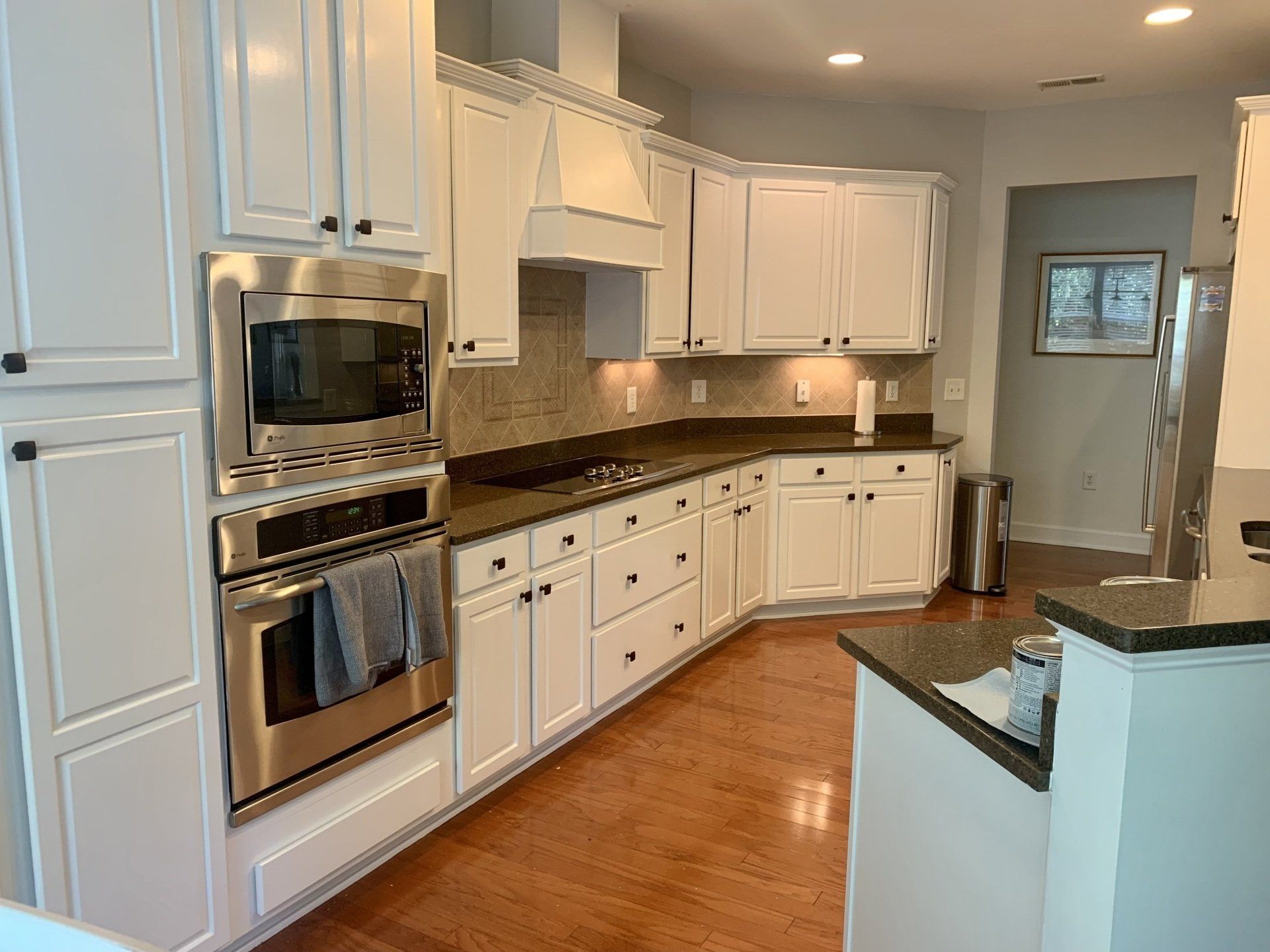A kitchen with white cabinets and stainless steel appliances