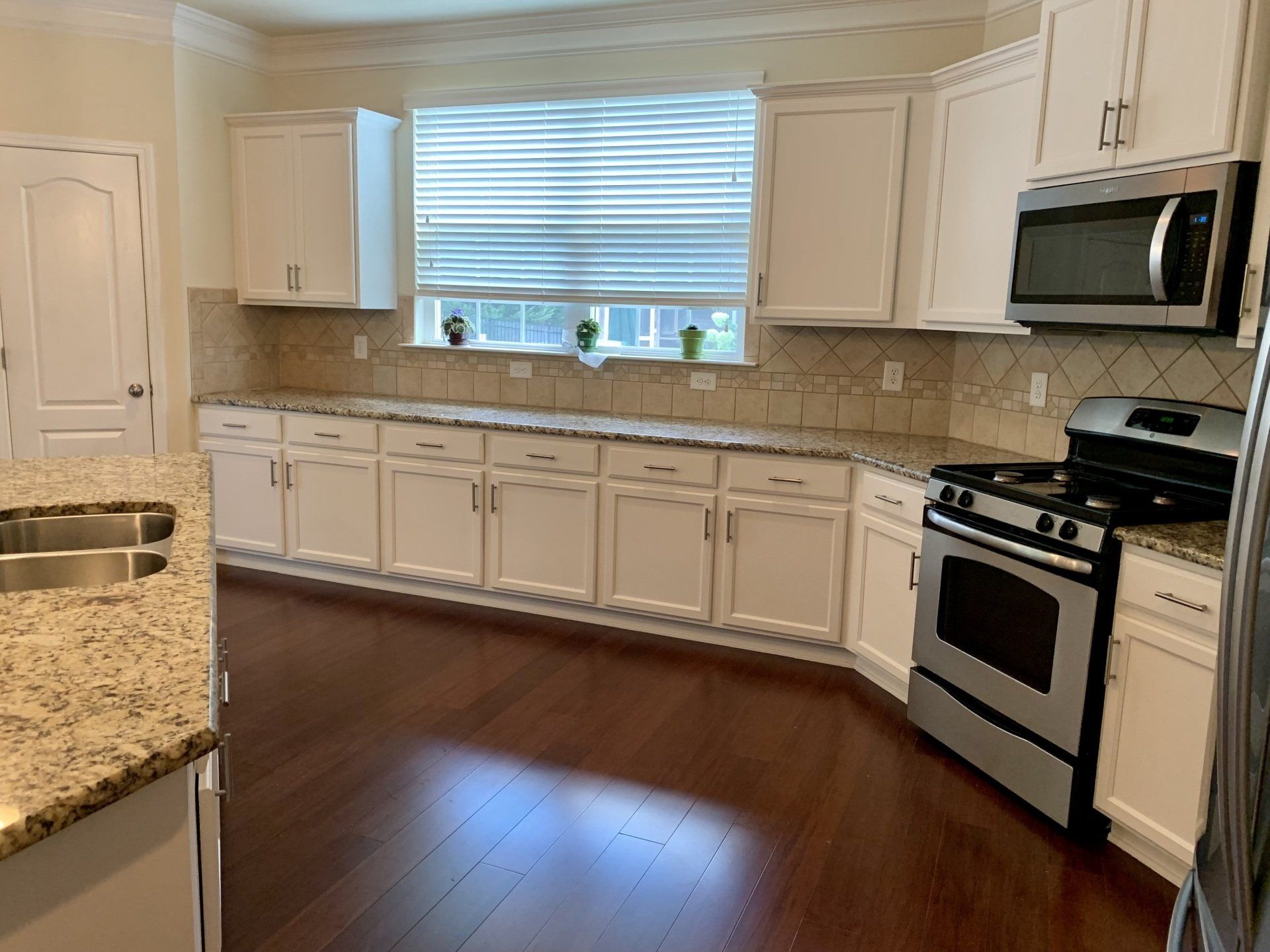A kitchen with white cabinets and stainless steel appliances