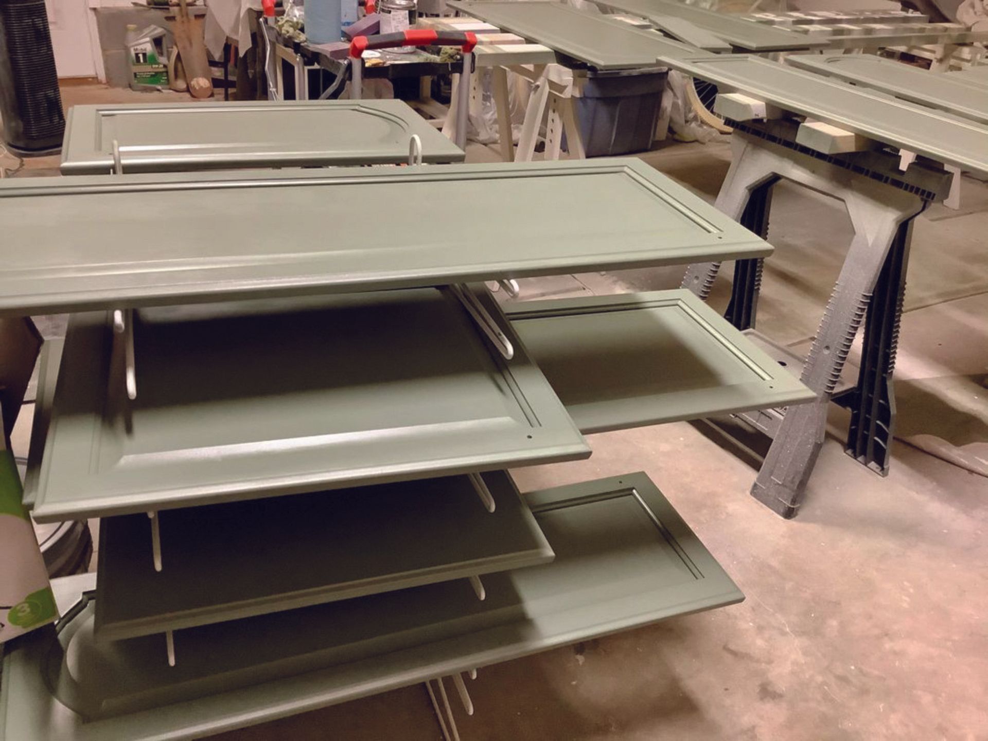 A stack of green cabinet doors sitting on top of each other on a table.