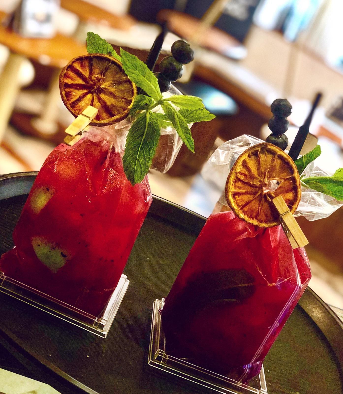 Due cocktail su un vassoio con cannucce e foglie di menta