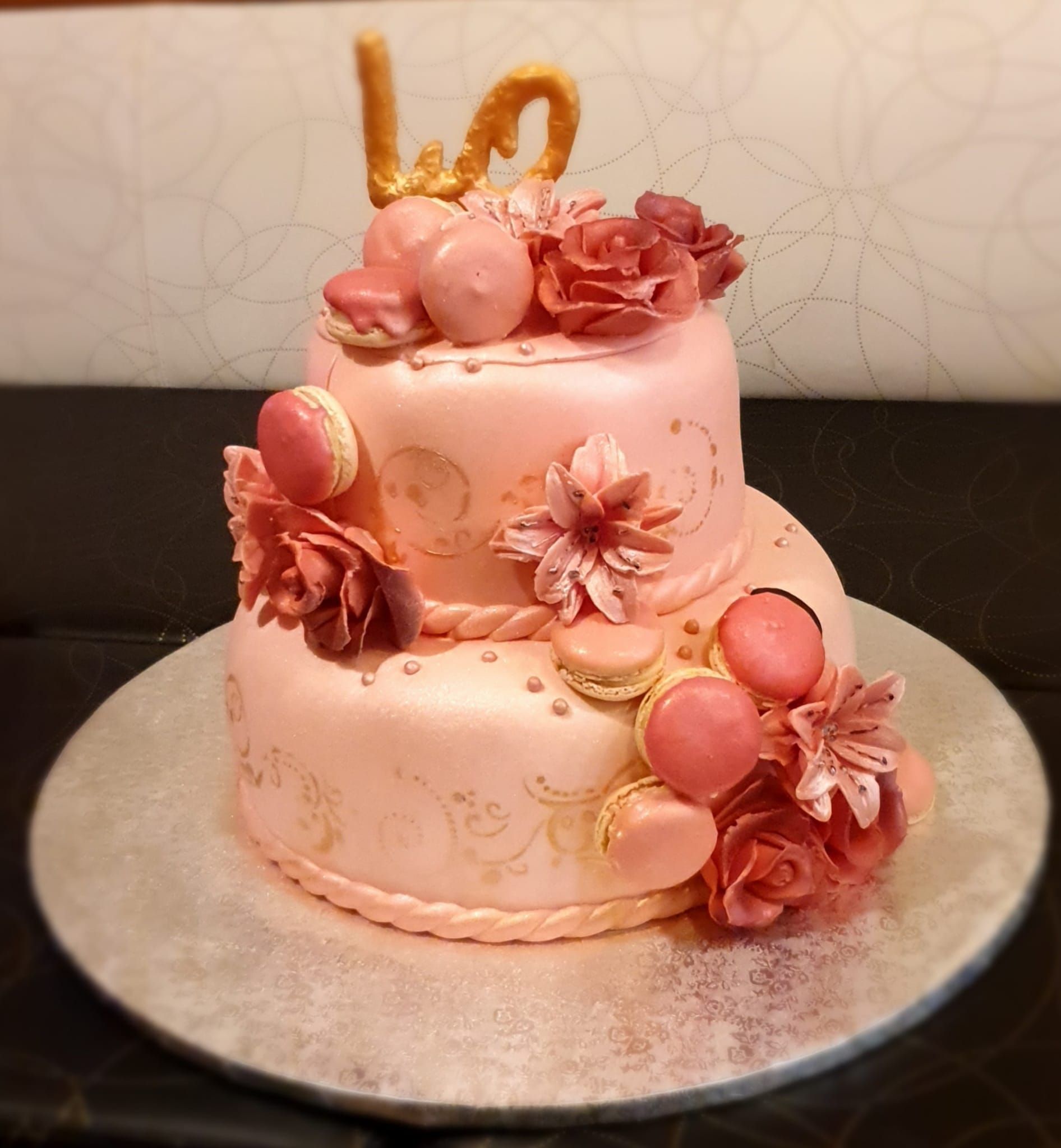 Una torta rosa con fiori e la parola amore sopra