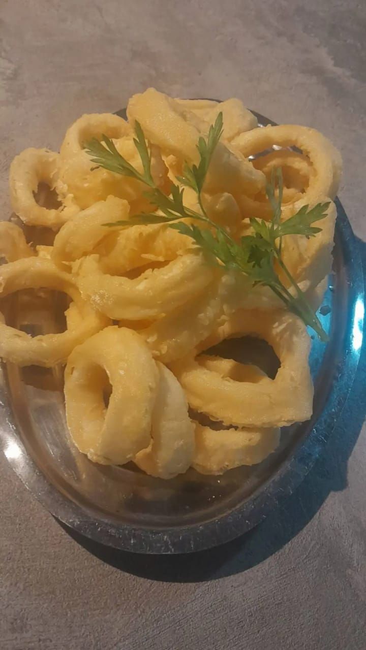 Parrilla comercial de acero inoxidable con tres quemadores y fondo rojo.