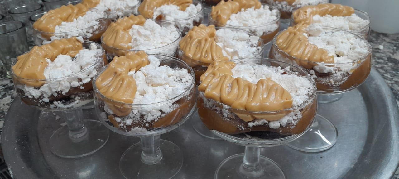 Plato de sushi sobre una mesa, varios rollos, una botella de vino, vasos, palillos y cuencos para mojar.