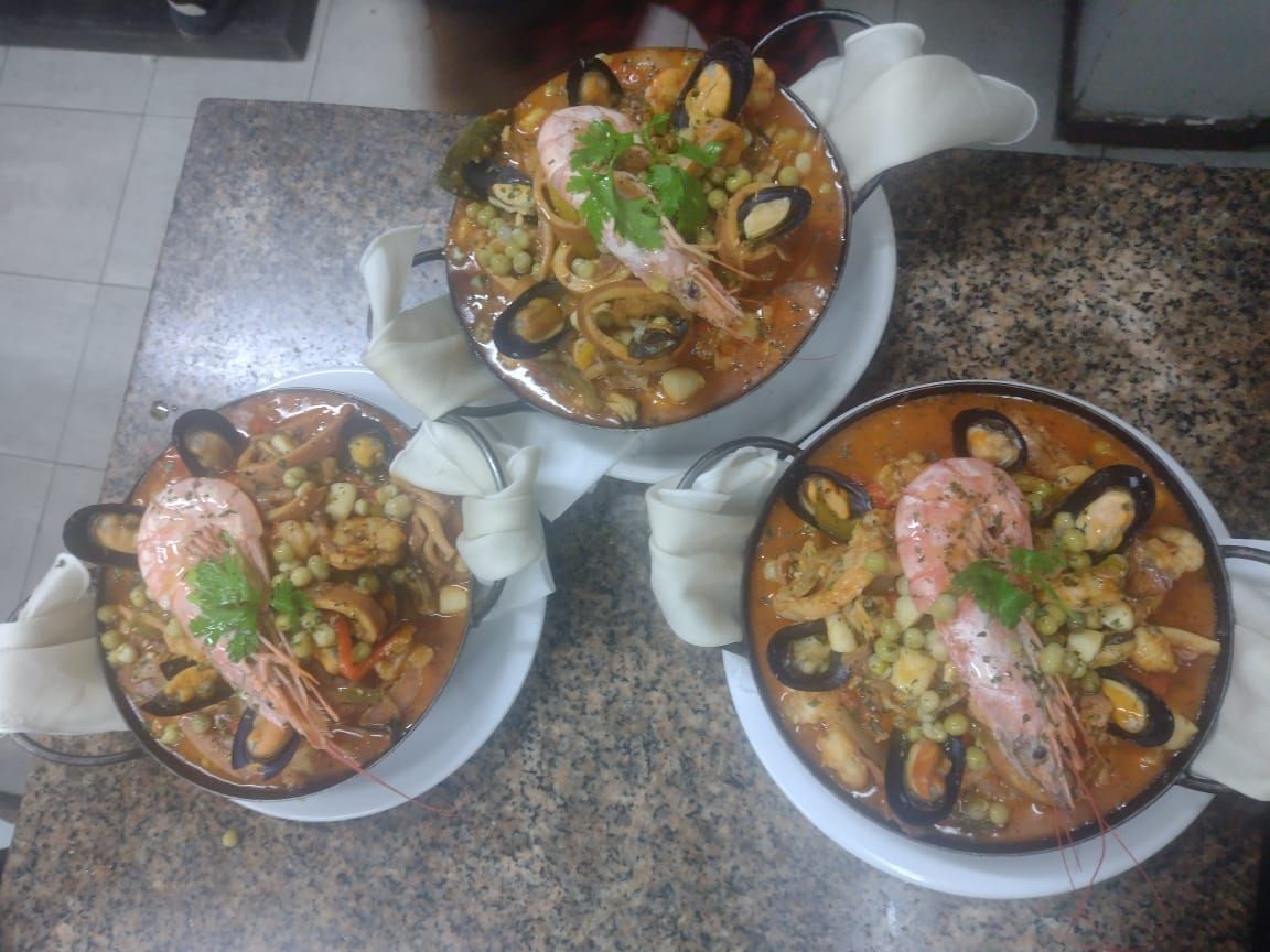 Tortilla española, parcialmente cortada, en un plato blanco, adornada con cebollino.