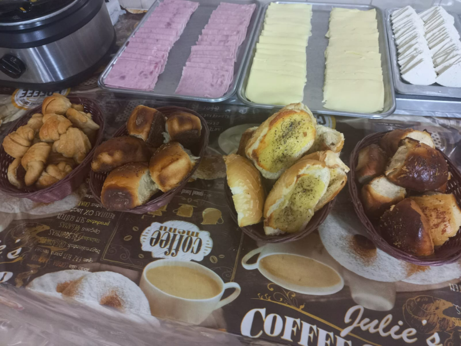 Café da manhã completo com pão, frios e queijo.
