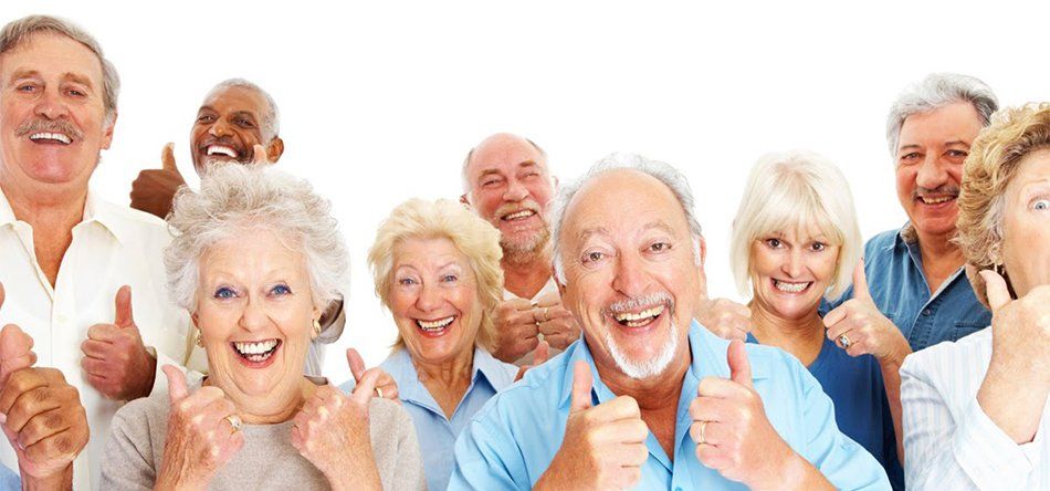 Group of smiling seniors giving thumbs up.