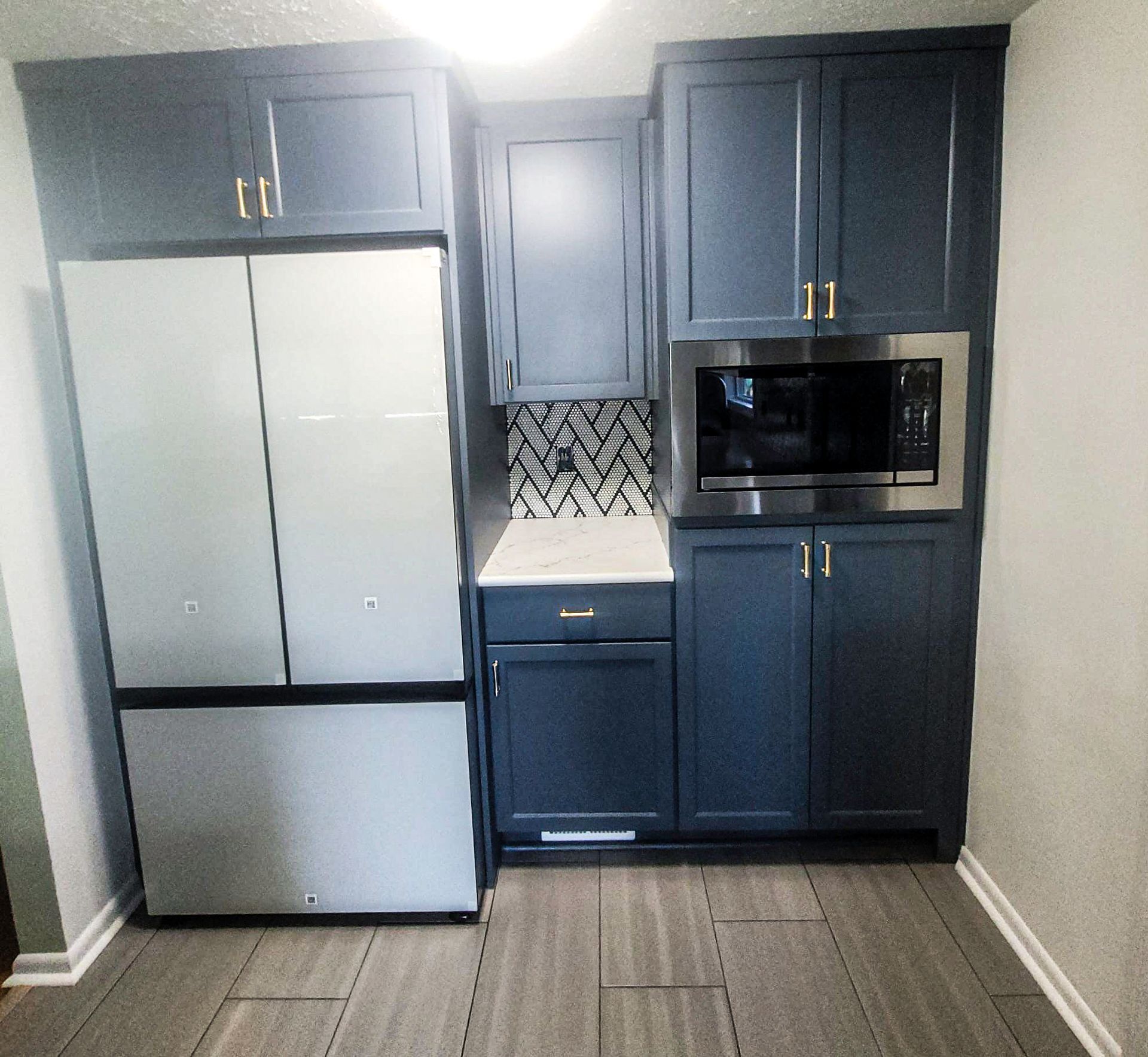 A kitchen with blue cabinets and stainless steel appliances