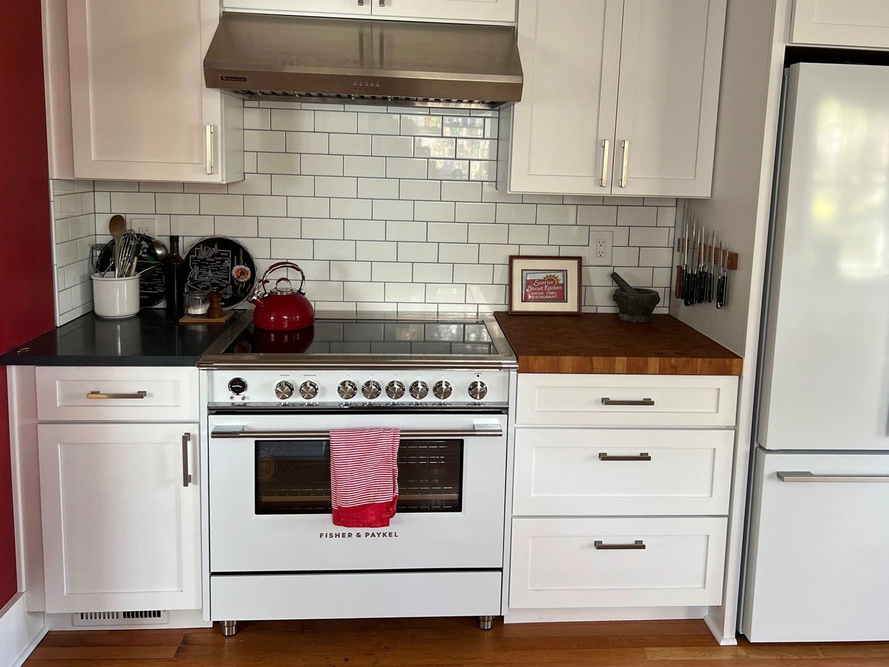 A kitchen with white cabinets and a white stove