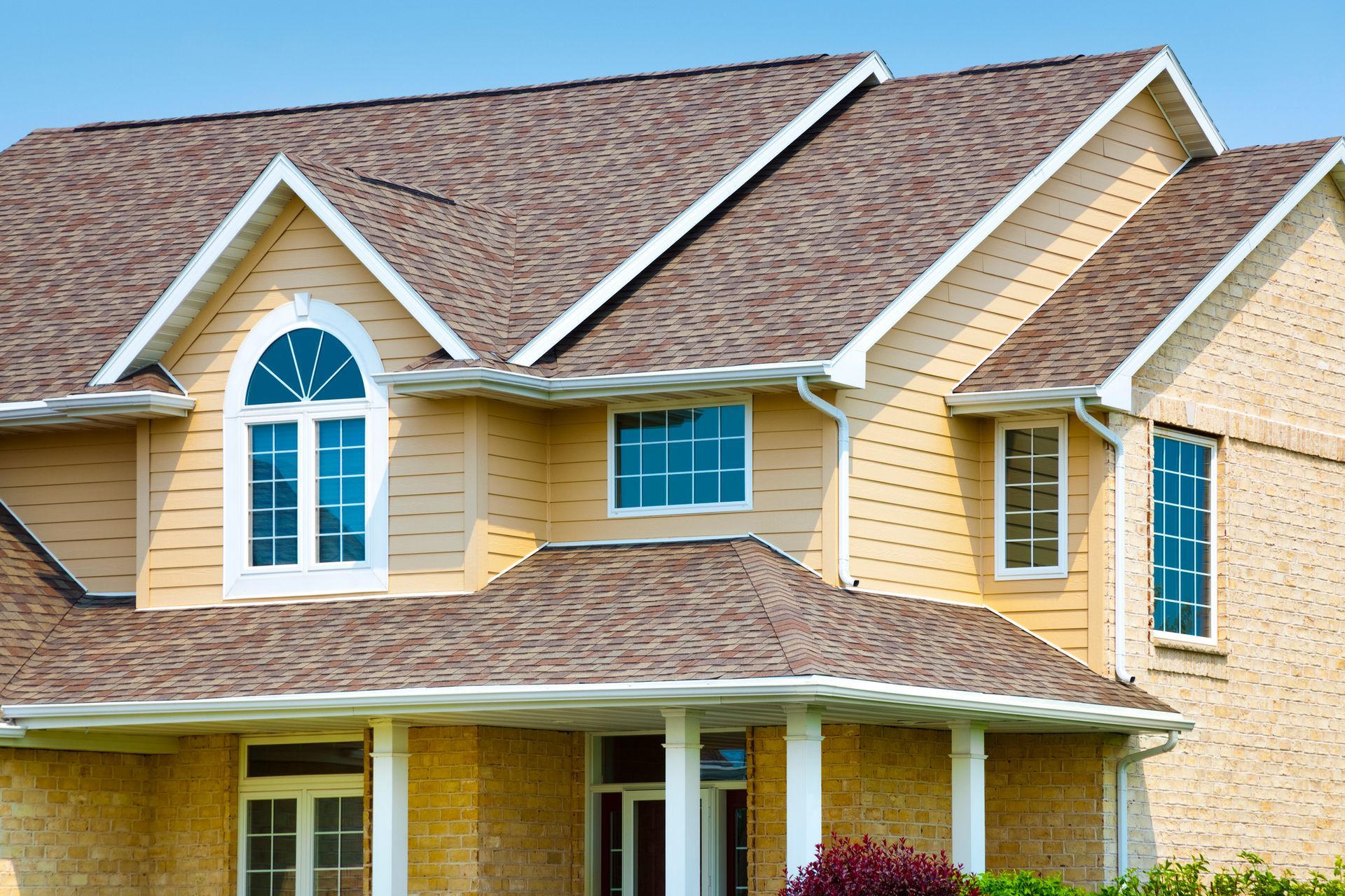 A large house with a brown roof and white trim