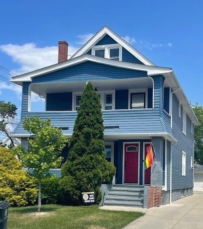 A ladder is sitting on the side of a white house.