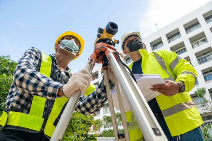Surveyor team civil engineer working with surveyor telescope equipment at building site
