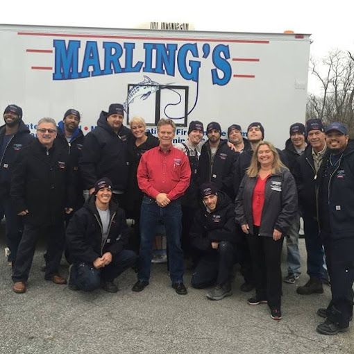 A group of people posing in front of a marling 's truck