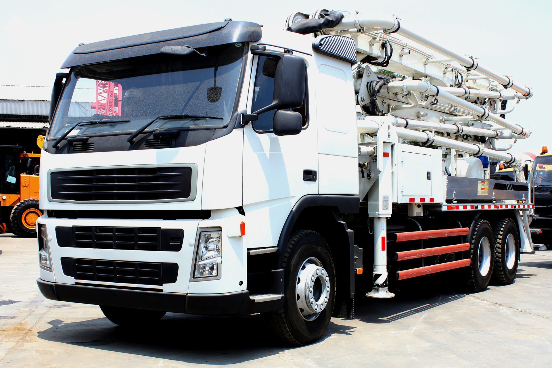 Concrete pump truck with multi-section boom mounted on the rear. Concrete pump truck with multi-section boom mounted on the rear.
