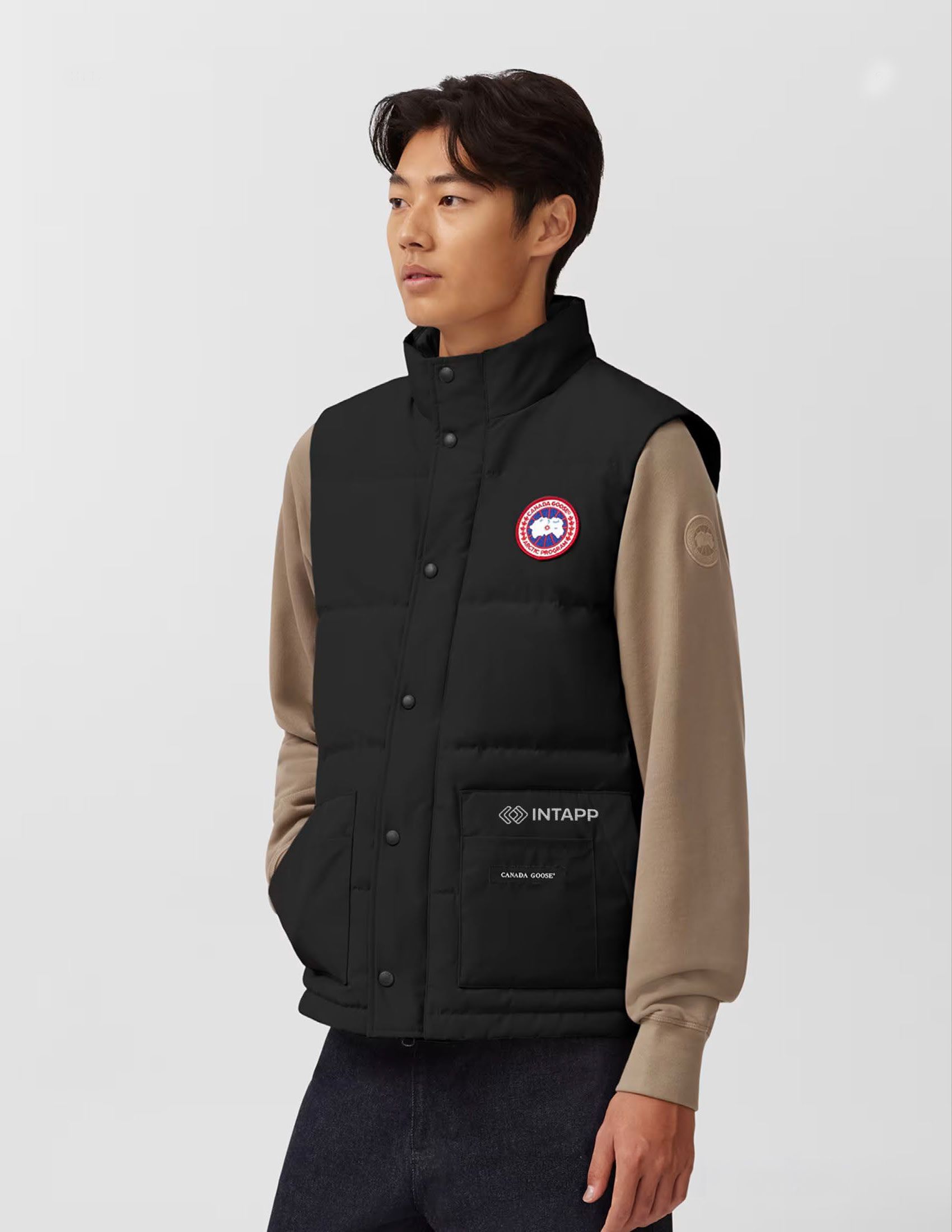 Man wearing a black Canada Goose vest with Intapp logo.