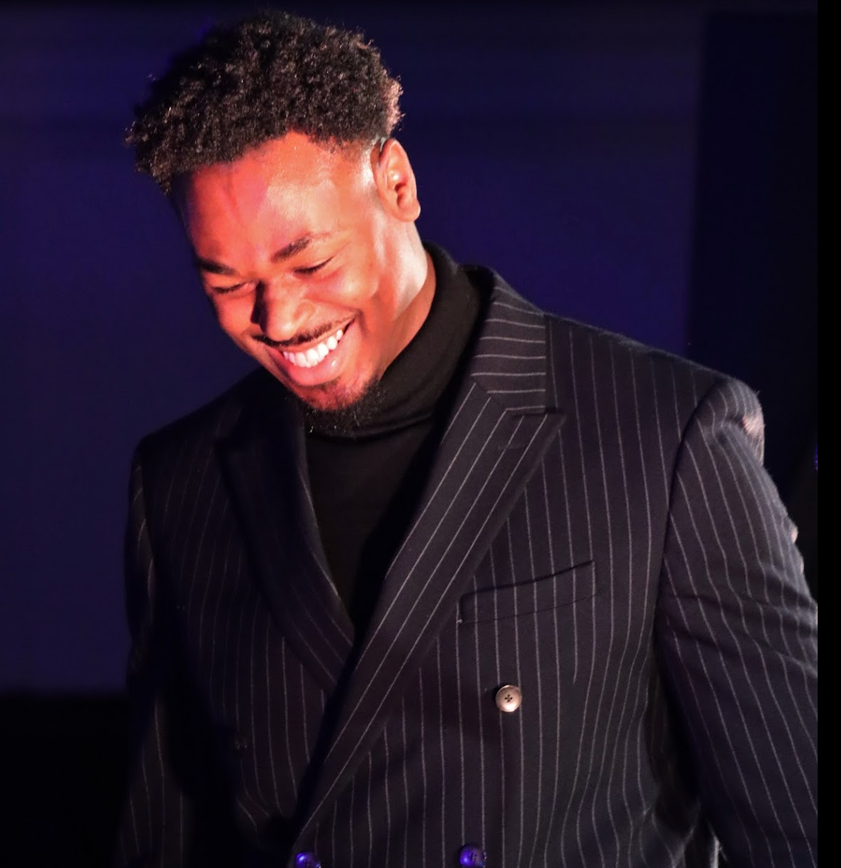 Man with short dark hair and goatee, wearing black shirt, looking at camera.