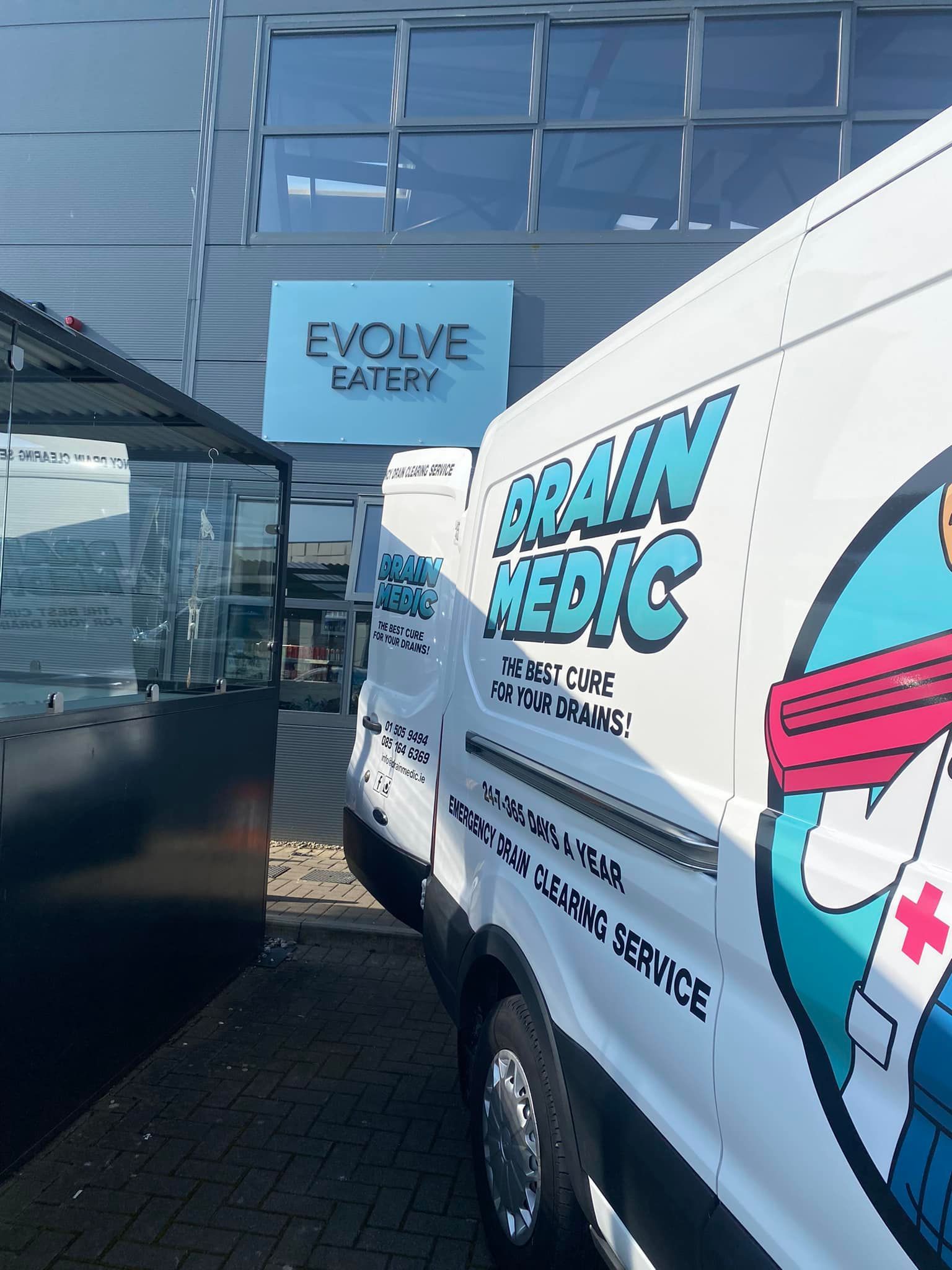 A bunch of vans parked in front of a building that says evolve eatery
