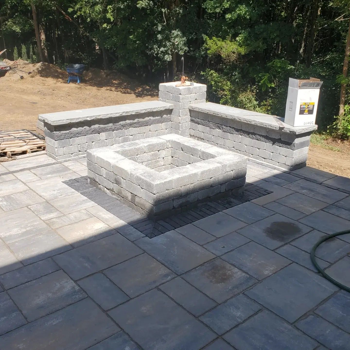 A man standing on a brick pillar in front of a house