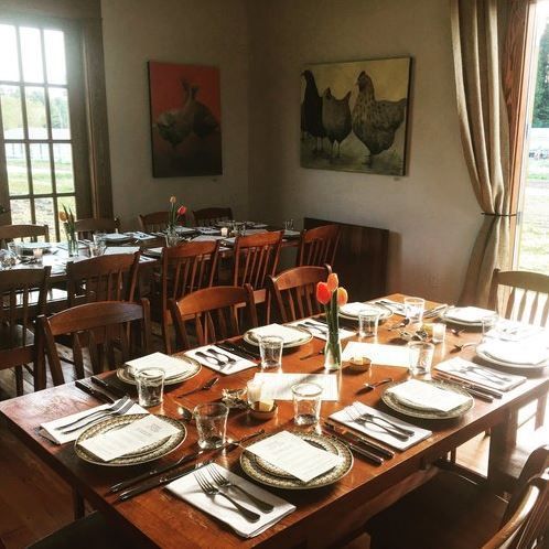 A dining room table with plates and utensils on it